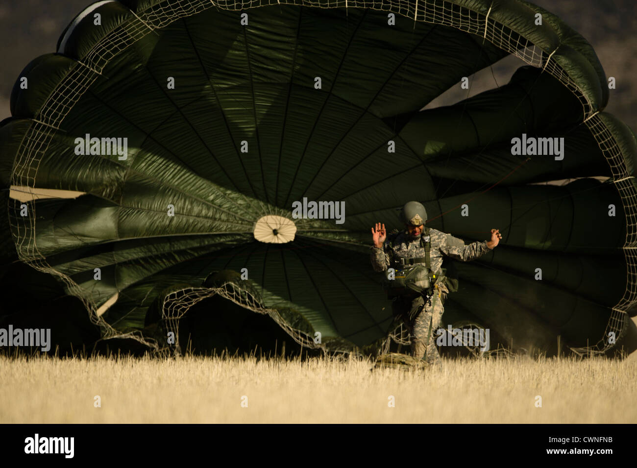 Un esercito americano soldato dell'Utah Guardia Nazionale si prepara a pacco il suo paracadute dopo una linea statica jump Marzo 15, 2012 in Fairfield, Utah. Foto Stock