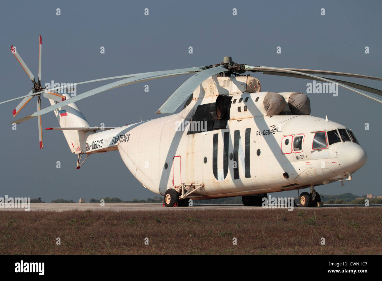 Mil Mi-26 trasporti pesanti elicottero parcheggiato sul terreno e il cuscinetto parzialmente dipinto fuori i titoli DELLE NAZIONI UNITE Foto Stock