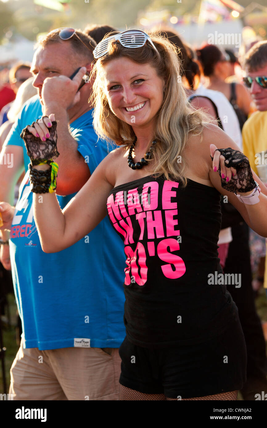 Giovane donna festival goer con 'Made in 80s' (nato negli anni ottanta) abito presso il Festival di riavvolgimento Henley on Thames 2012. JMH6037 Foto Stock