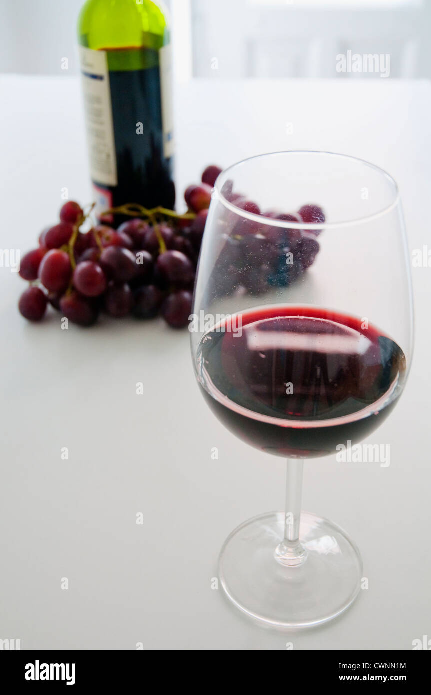 Ancora in vita: un bicchiere di vino rosso, bottiglia e grappolo di uva. Foto Stock