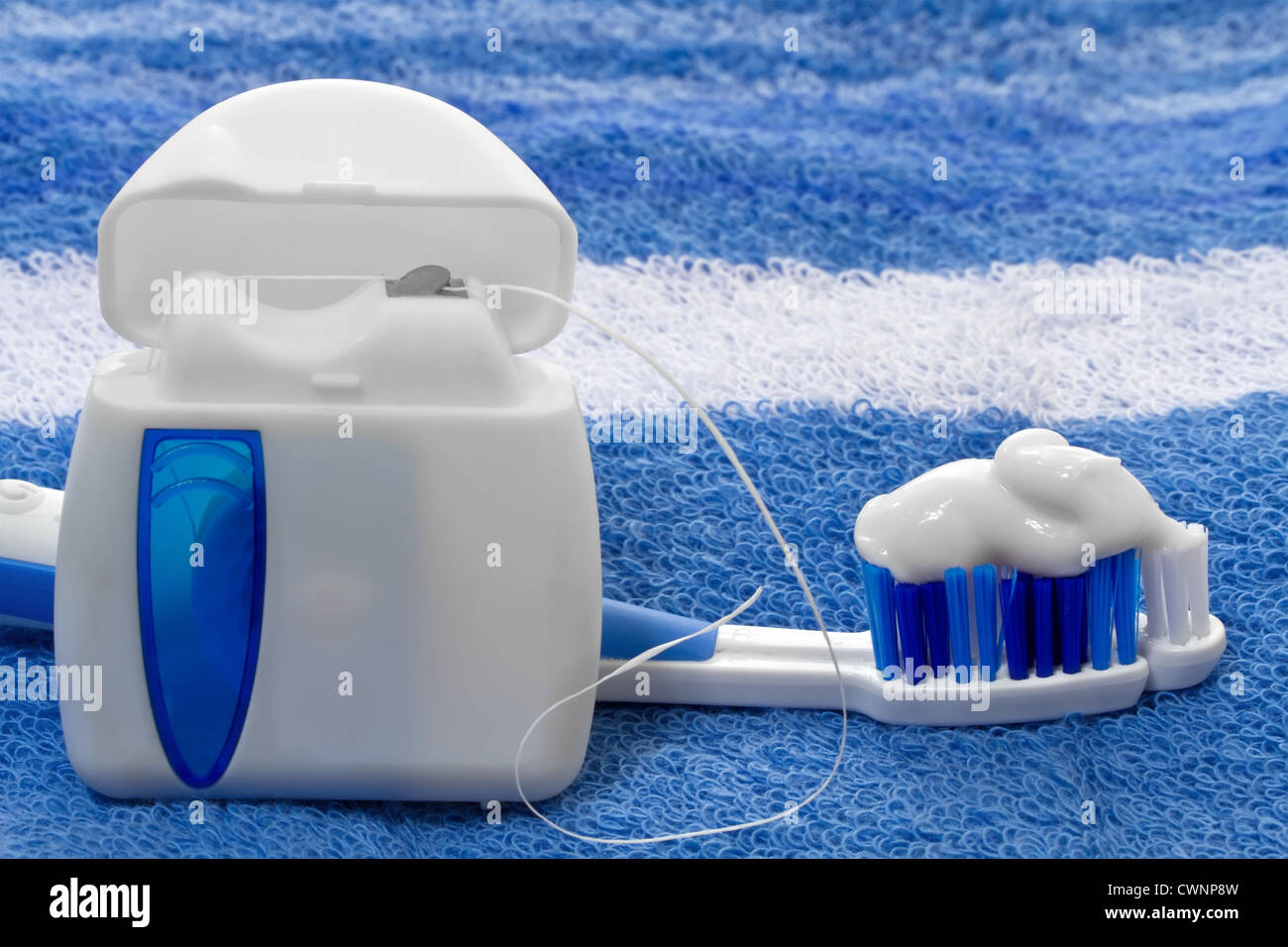Il filo interdentale e spazzolino da denti su un asciugamano Foto Stock