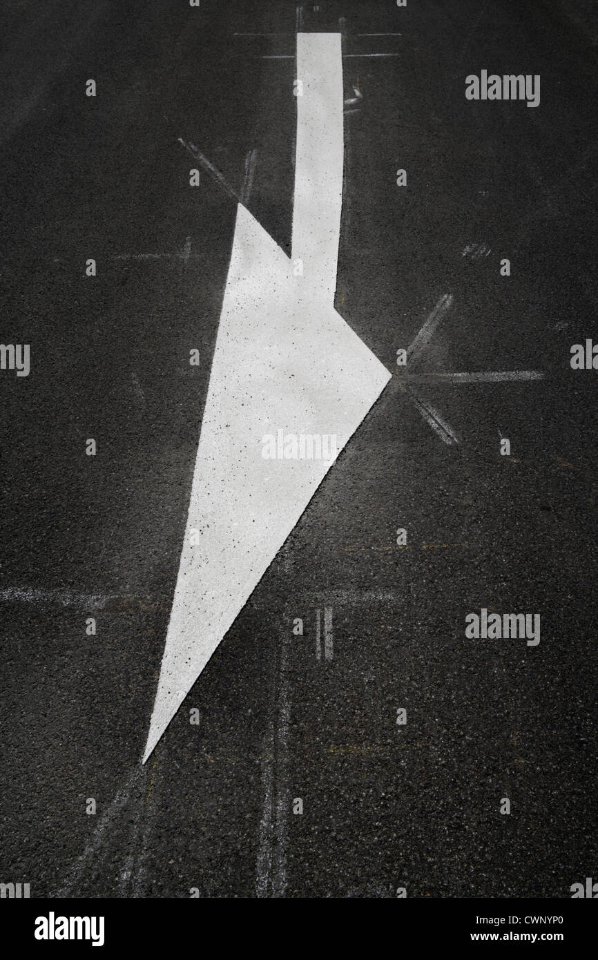 In Germania, in Baviera, la vista di freccia bianca segno marcatura su strada Foto Stock