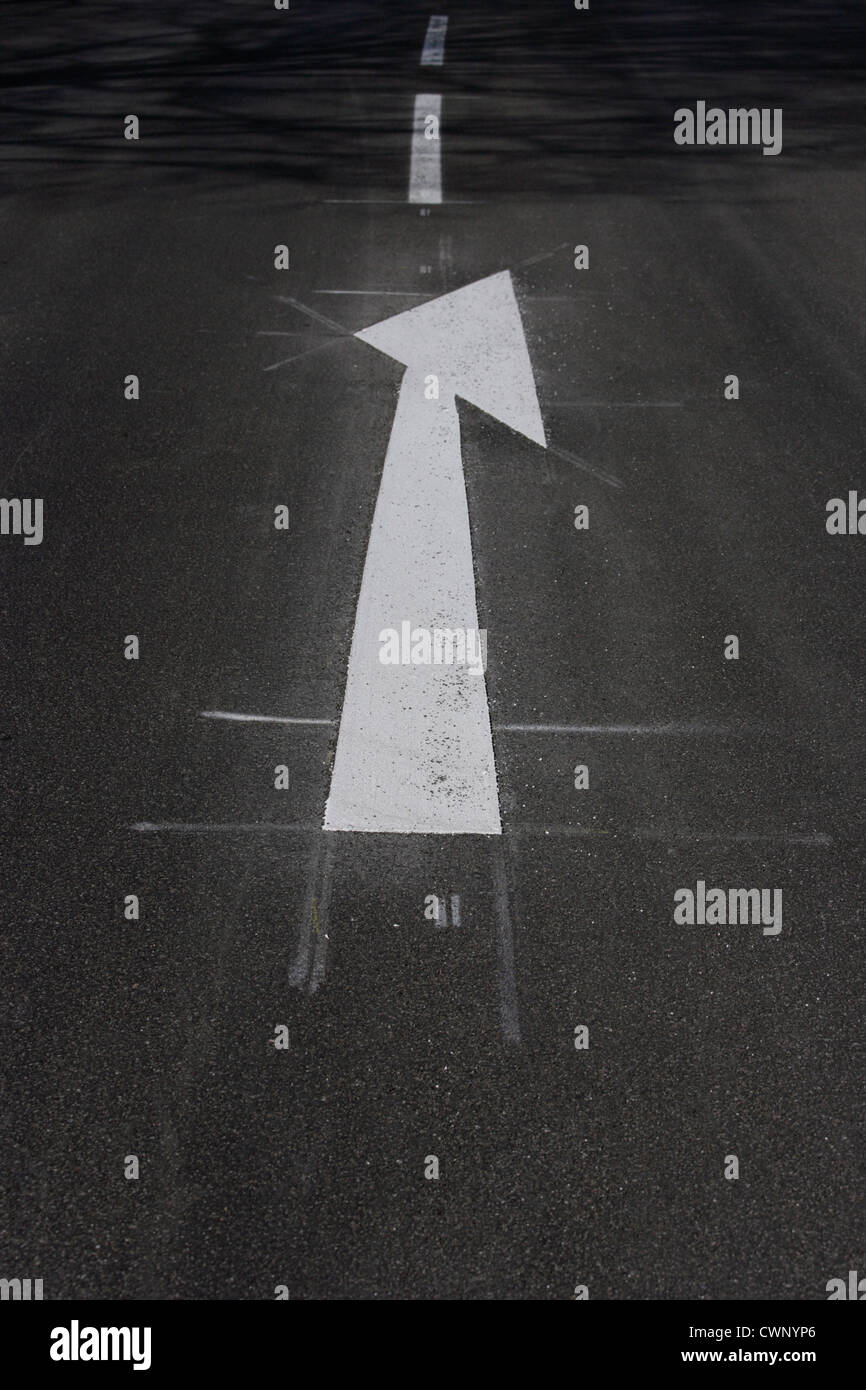 In Germania, in Baviera, la vista di freccia bianca segno marcatura su strada Foto Stock