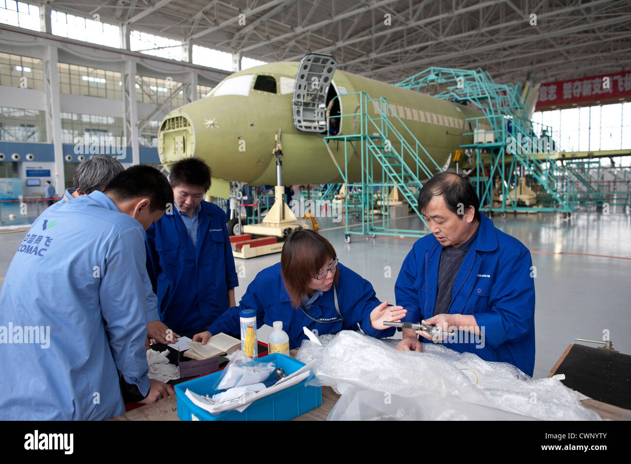Ingegneri cinesi e dei lavoratori verificare le parti di un ARJ21 aereo passeggeri in costruzione a Shanghai. Foto Stock