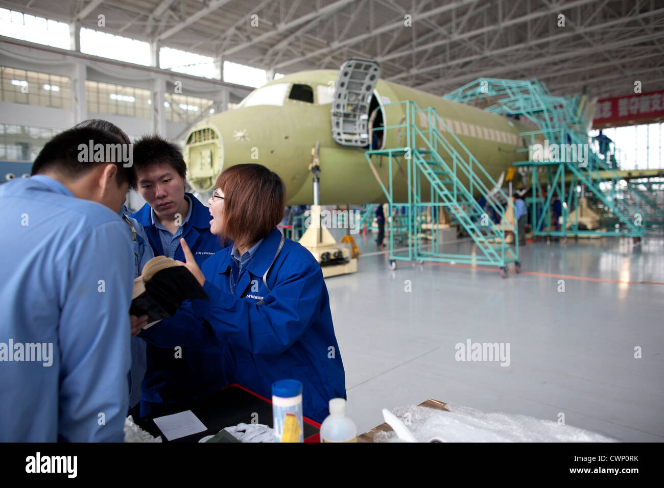Ingegneri cinesi e dei lavoratori verificare le parti di un ARJ21 aereo passeggeri in costruzione a Shanghai. Foto Stock