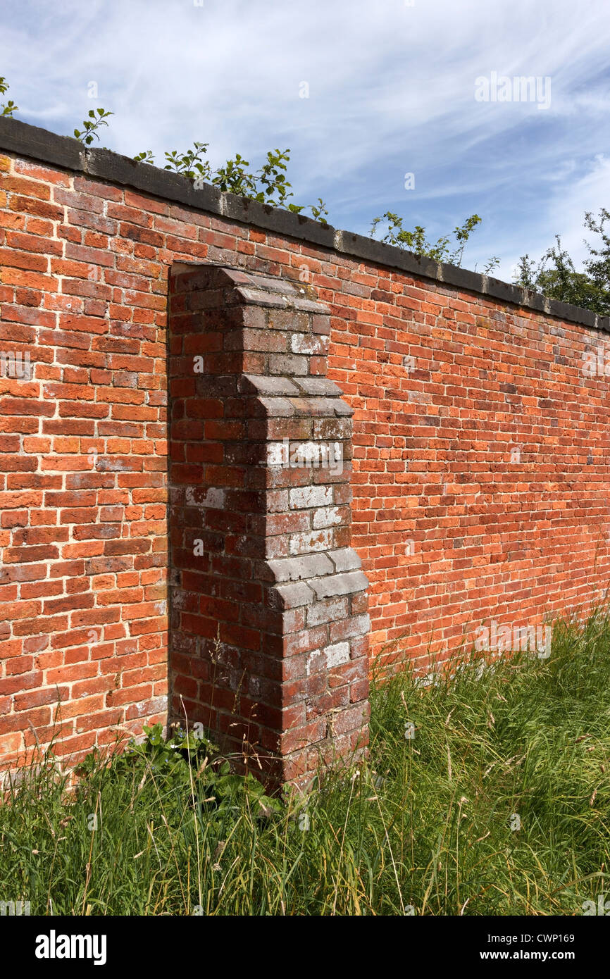 Vecchio rustico rosso mattone parete giardino con contrafforte, Derbyshire, England, Regno Unito Foto Stock