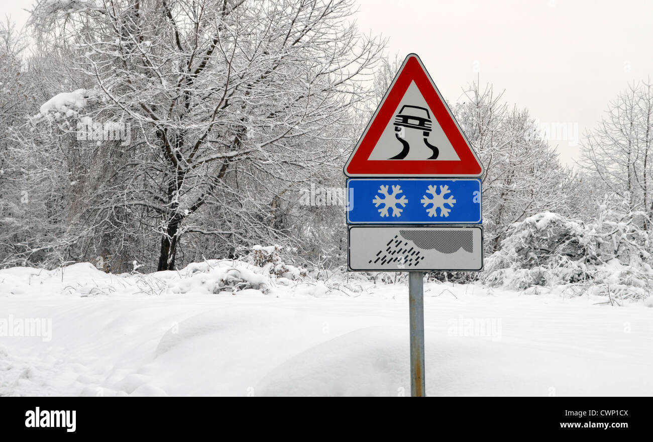 Strada sdrucciolevole segno nella neve. Condizioni climatiche Foto Stock
