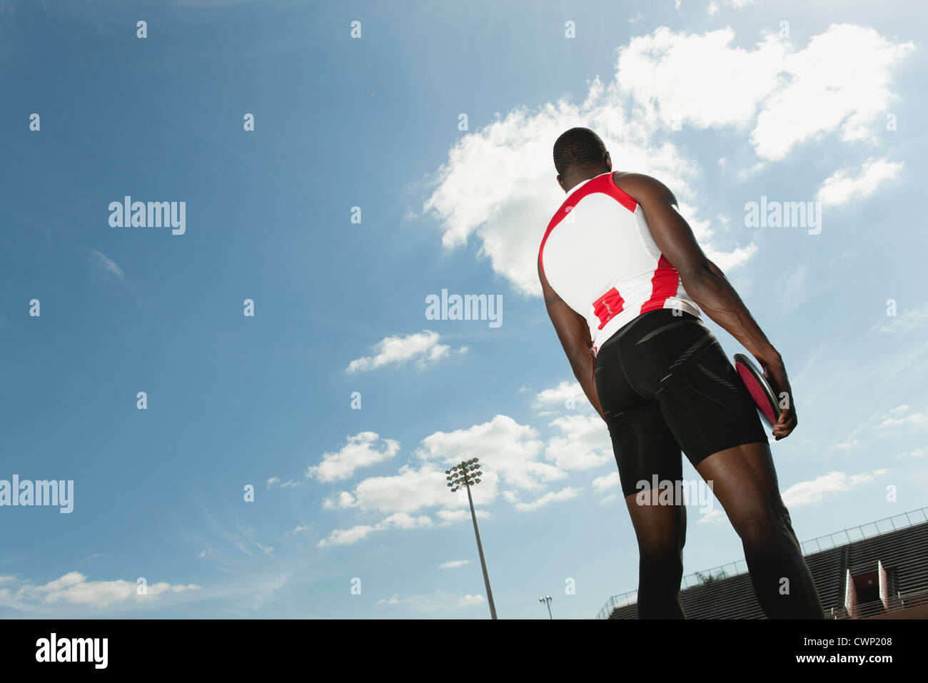 Atleta maschio holding discus, vista posteriore Foto Stock