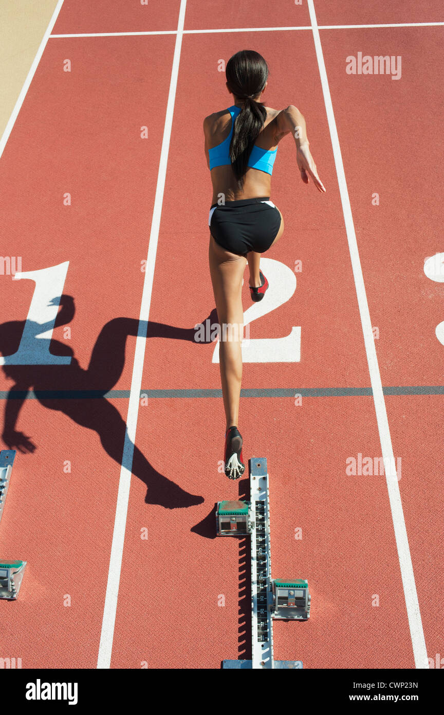 Atleta femminile lasciando la linea di partenza, vista posteriore Foto Stock