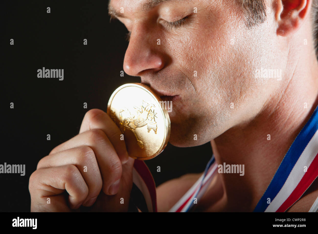 Atleta kissing medaglia d'oro Foto Stock