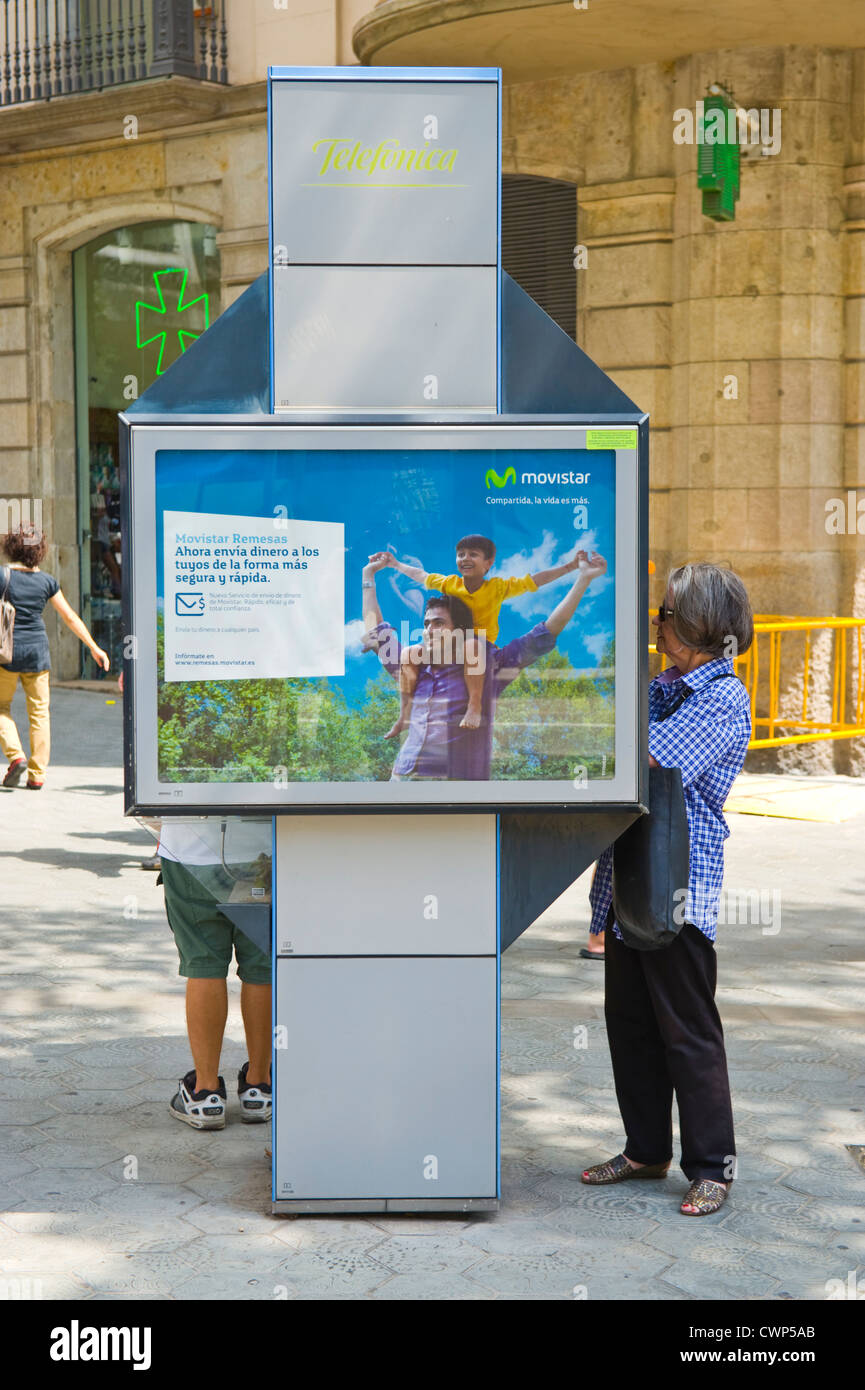 Le persone che usano telefoni pubblici su strada di Barcellona e della Catalogna, Spagna, ES Foto Stock