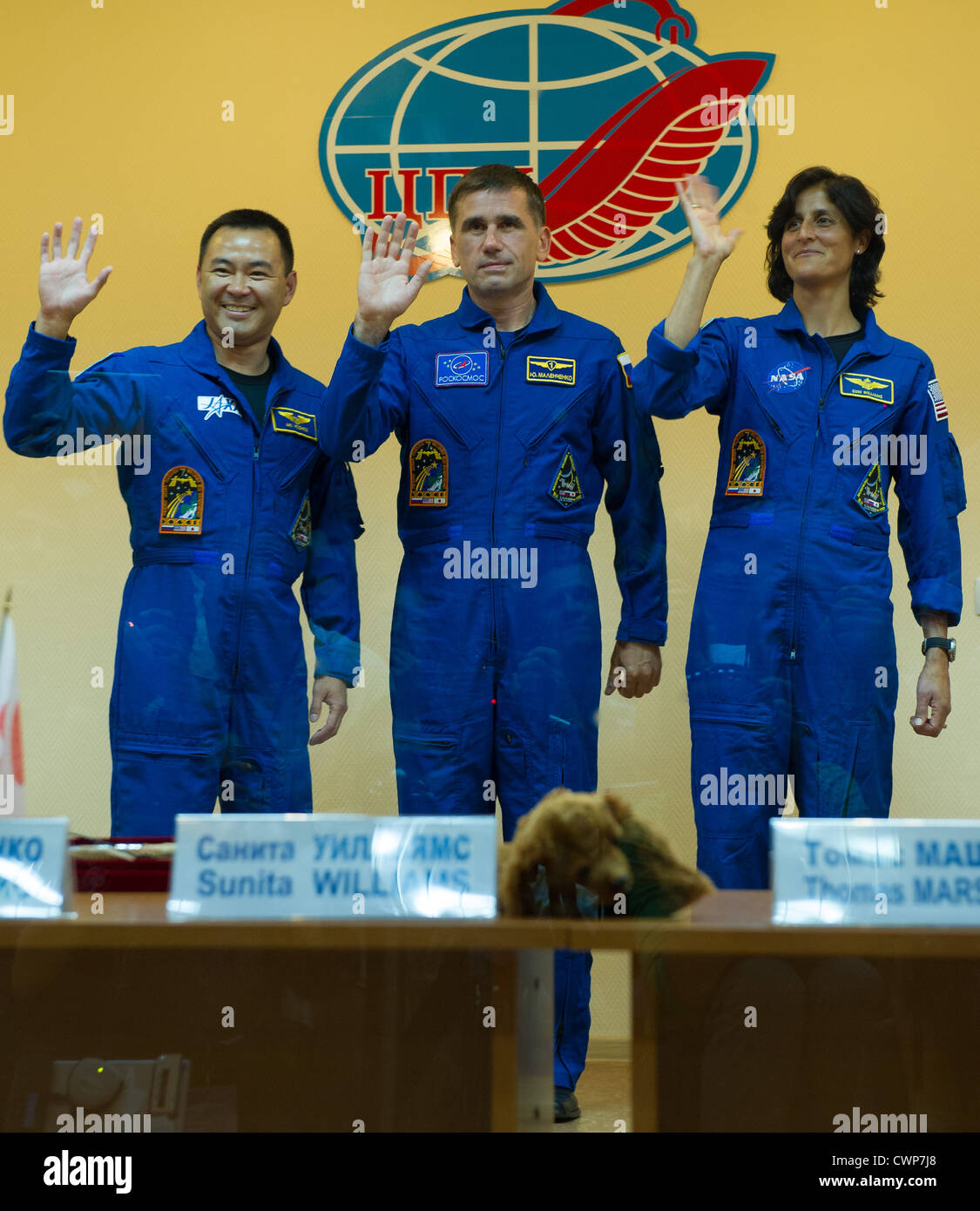 Spedizione in quarantena Soyuz 32 il primo equipaggio, da sinistra, JAXA tecnico di volo Akihiko Hoshide, russo Soyuz Commander Yuri Malenchenko, NASA tecnico di volo Sunita Williams Wave addio da dietro il vetro durante un prelaunch conferenza stampa al cosmonauta Hotel il Venerdì, 13 luglio 2012 di Baikonur in Kazakhstan. Foto Stock