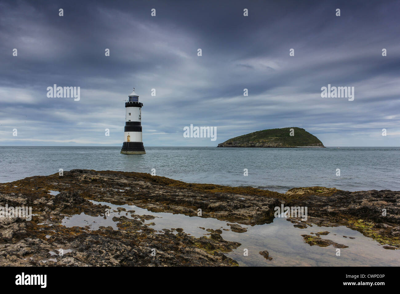 Penmon Point lighthouse con Puffin Island in background sull'Isola di Anglesey, Galles del Nord. Foto Stock