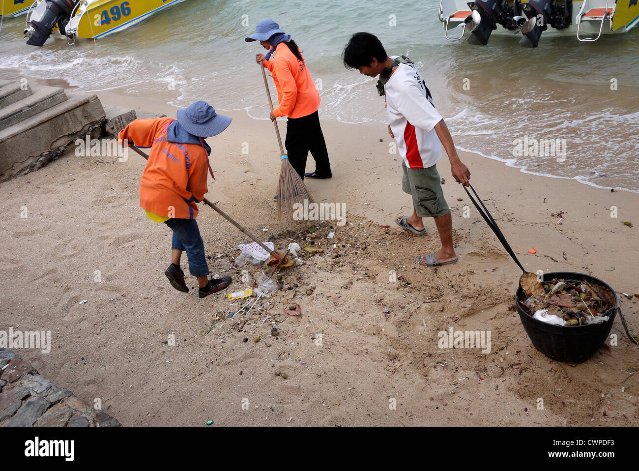 Spiaggia pulitori sweep e cancellare i rifiuti dalla spiaggia di Pattaya Thailandia Foto Stock