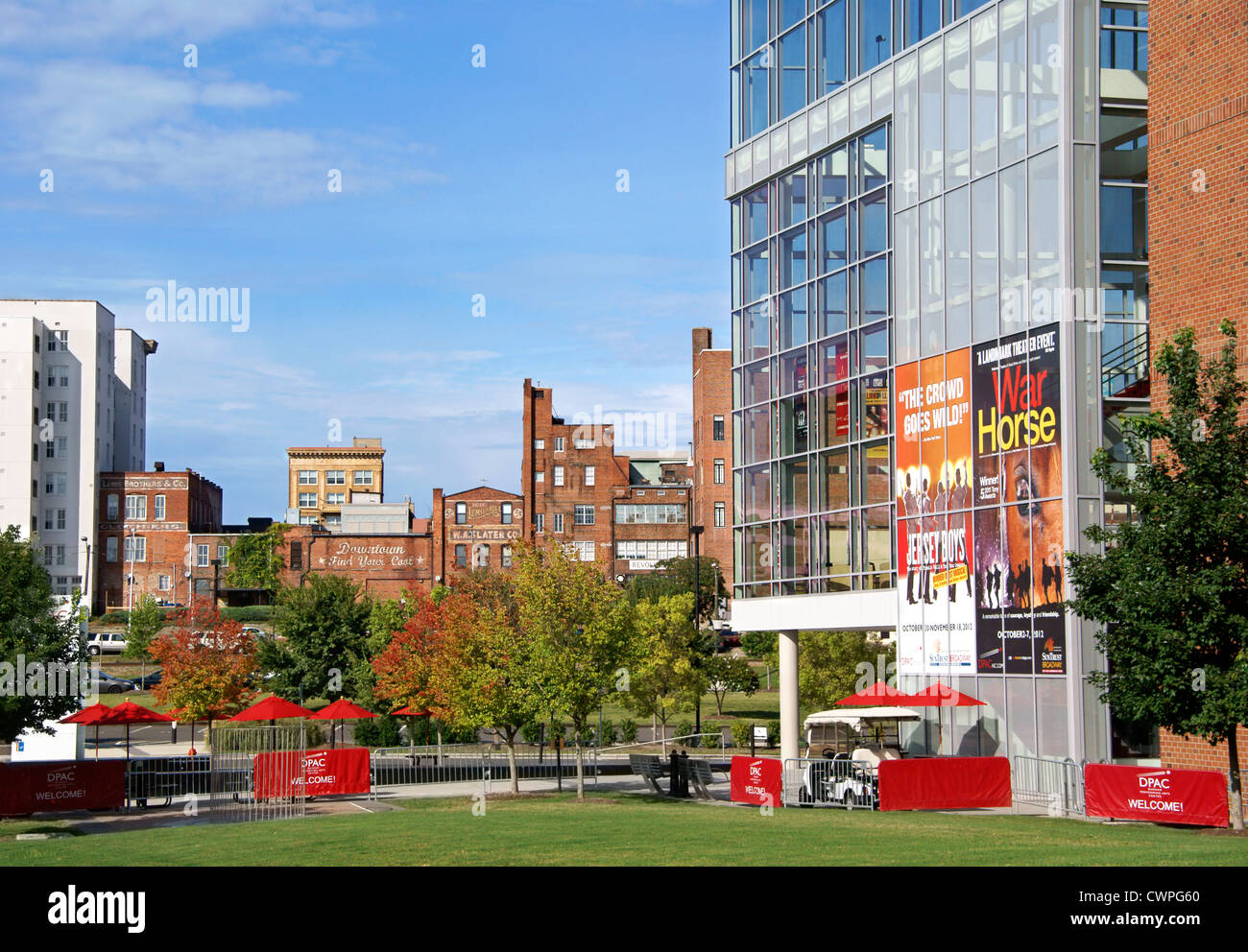 Durham, North Carolina, nc. durham performing arts center in primo piano che si affaccia su vecchi edifici in mattoni di downtown. Foto Stock