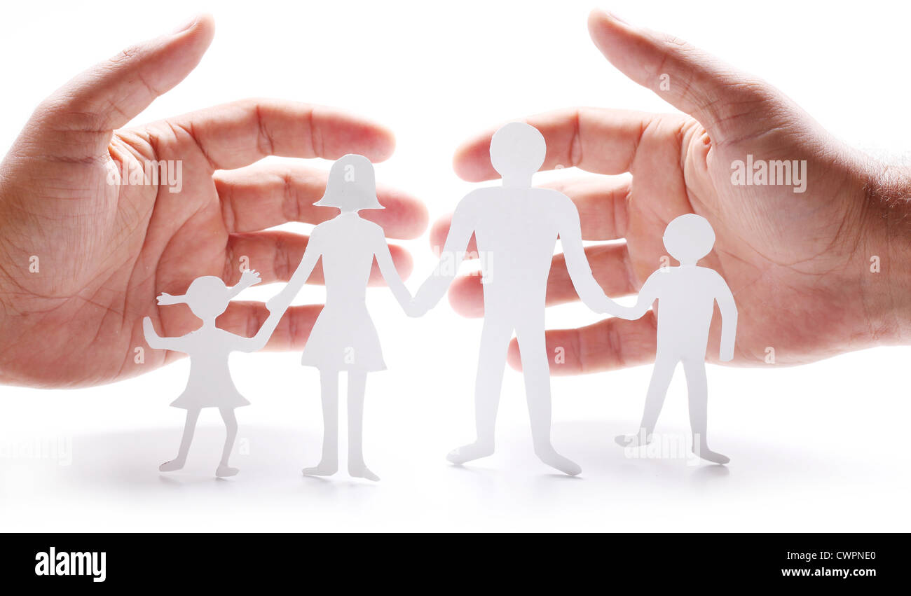Figure di cartone della famiglia su uno sfondo bianco. Il simbolo di unità e di felicità. Le mani abbraccio delicatamente la famiglia. Foto Stock