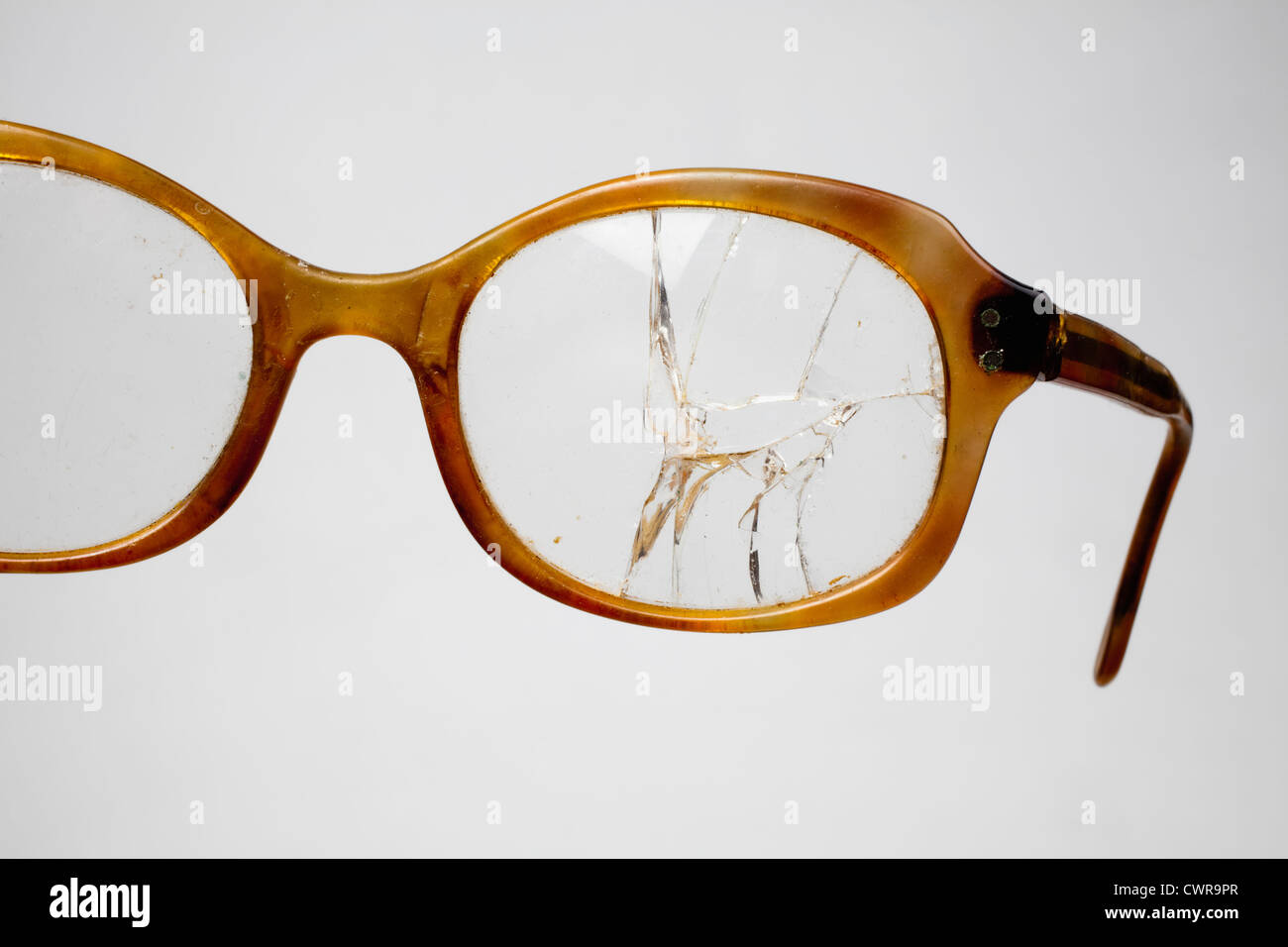 Una vecchia tromba cerchiati di occhiali con una lente incrinato Foto Stock