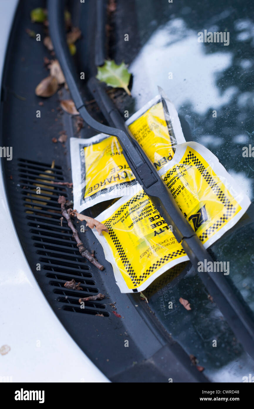 Due biglietti di parcheggio attaccata al finestrino di un'automobile a Londra REGNO UNITO. La vettura sembra essere stato per qualche tempo. Foto Stock