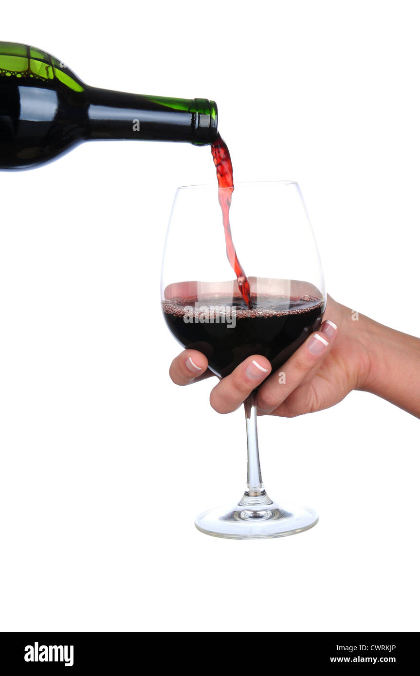 Vista dettagliata del vino rosso versata da una bottiglia in un bicchiere tenuto in una mano womans. Formato verticale su uno sfondo bianco. Foto Stock