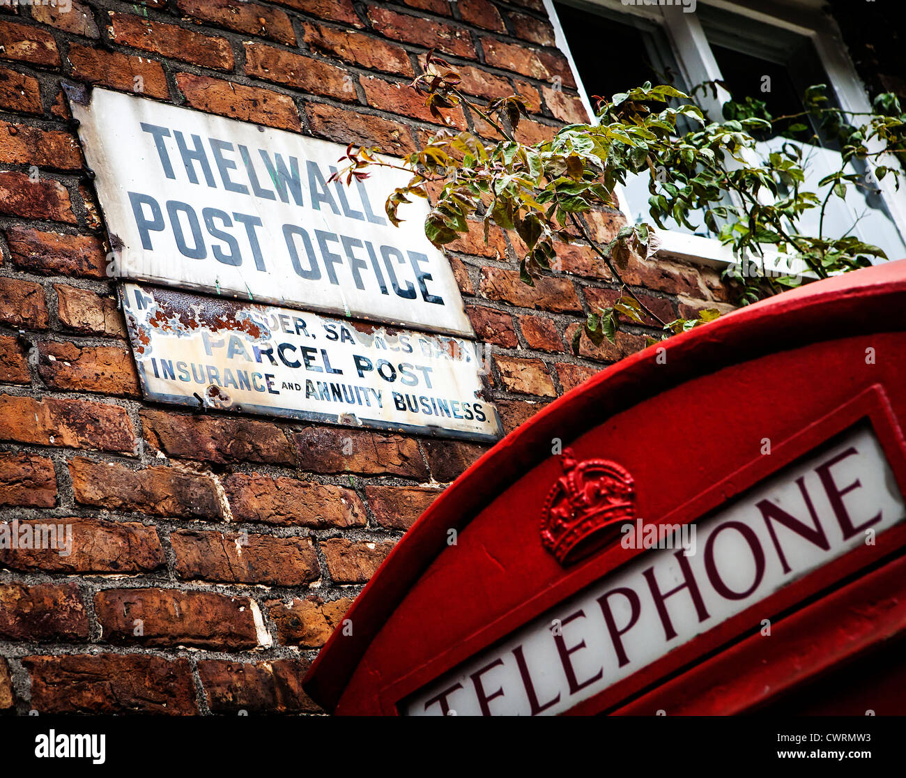 Segno al di fuori del vecchio Thelwall post office con un telefono nelle vicinanze box Foto Stock