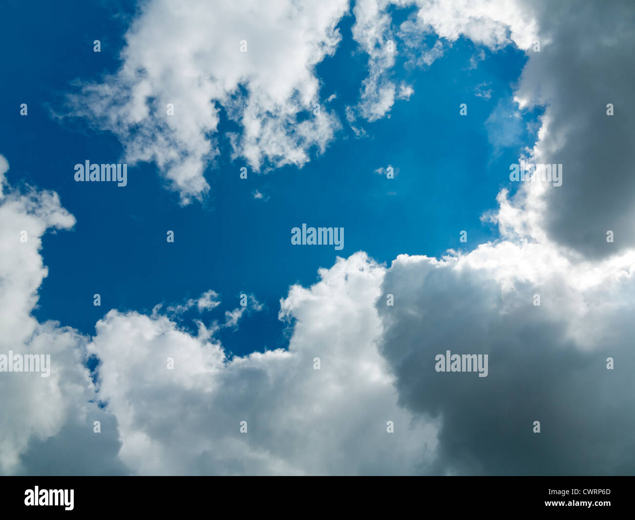 Ricco blu cielo bianco con copertura di nuvole che oscurano il sole che sta per bruciare attraverso Foto Stock