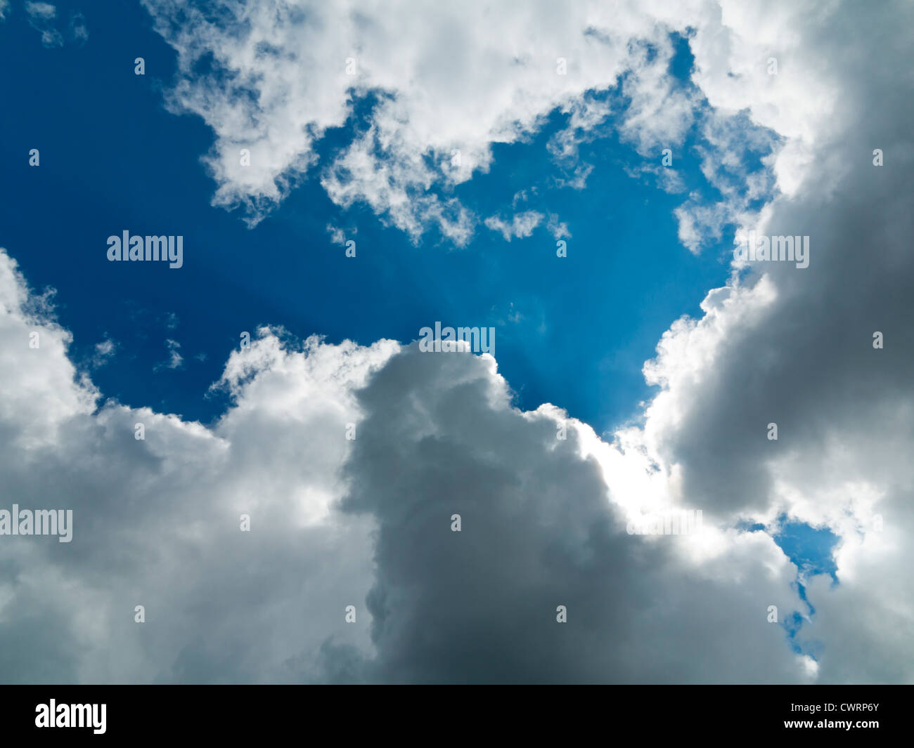 Ricco blu cielo bianco con copertura di nuvole che oscurano il sole che sta per bruciare attraverso Foto Stock