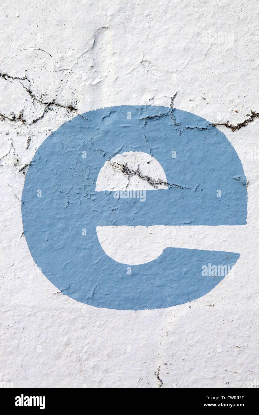 Lettera minuscola " e " nel cielo della vernice blu stampata su di sbriciolamento di parete esterna, UK. Per le altre lettere vedi Nick Sinclair folio Foto Stock