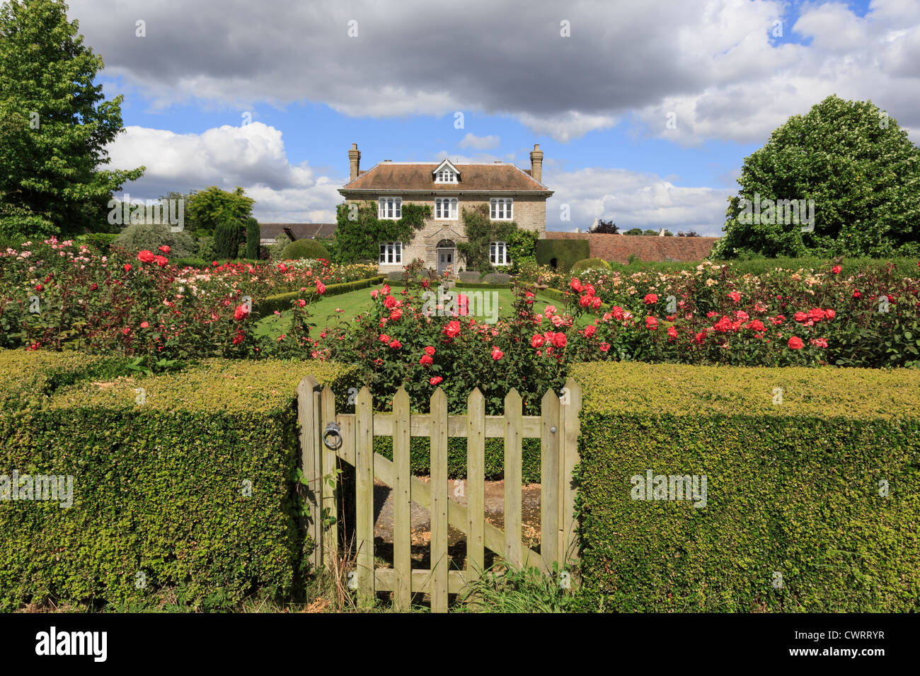 Hedge con gate al rose garden di fronte a 19C English country house in estate. Pluckley, vicino a Ashford, Kent, Regno Unito Foto Stock