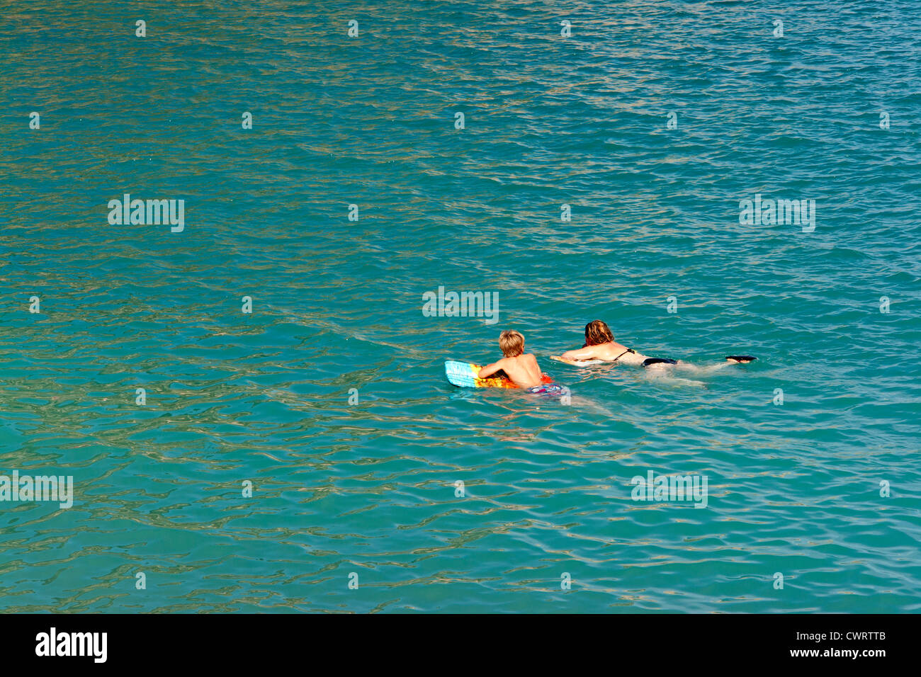 Due bambini su un lilo in mare Foto Stock