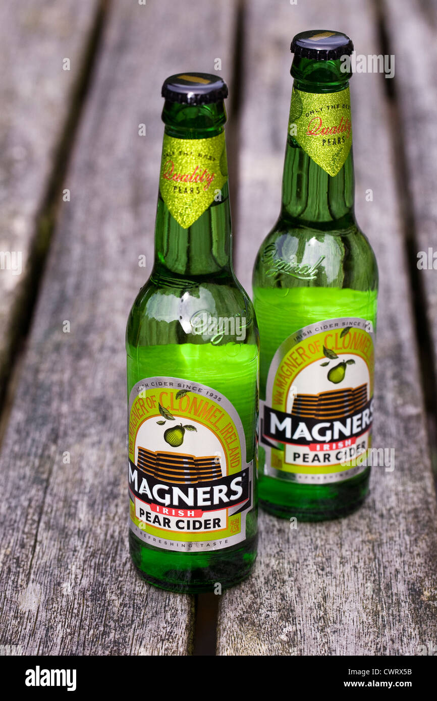 Bottiglie di Magners sidro di pere su di un tavolo di legno. Foto Stock