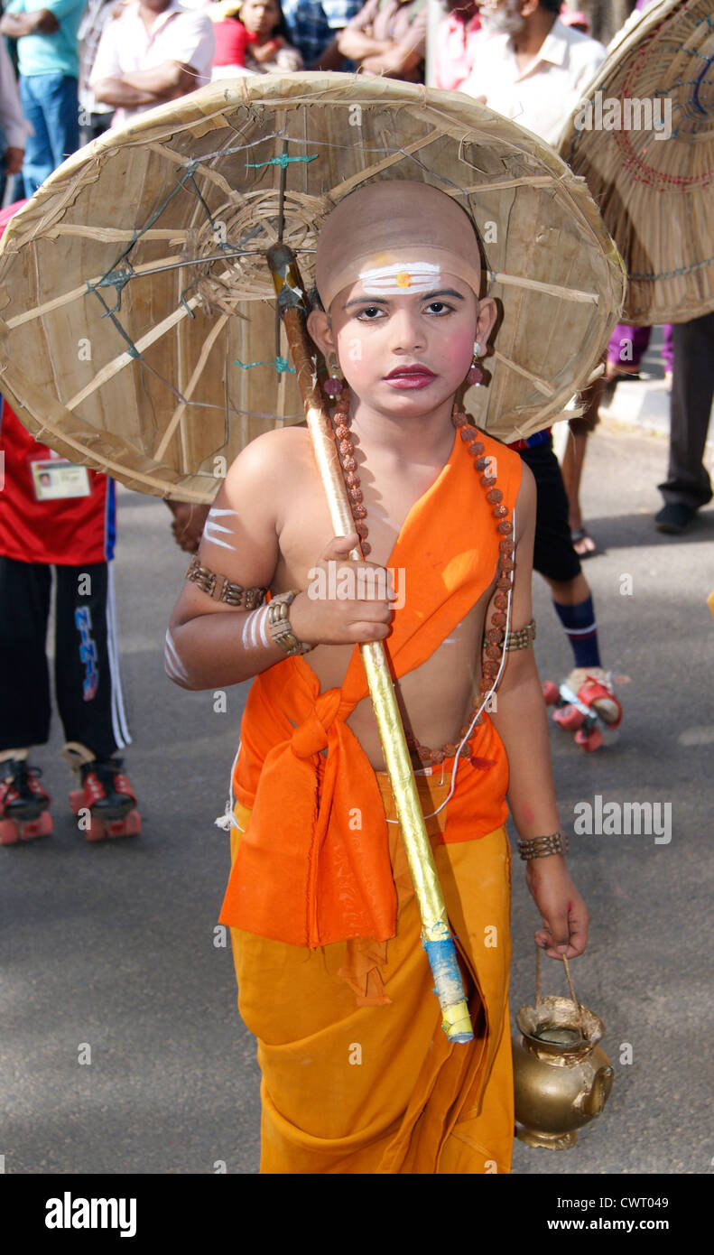 Carattere Vamanan in Onam Festival.Un ragazzo vestito e agire come Vamanan con tradizionale ombrellone e saint abiti. Foto Stock