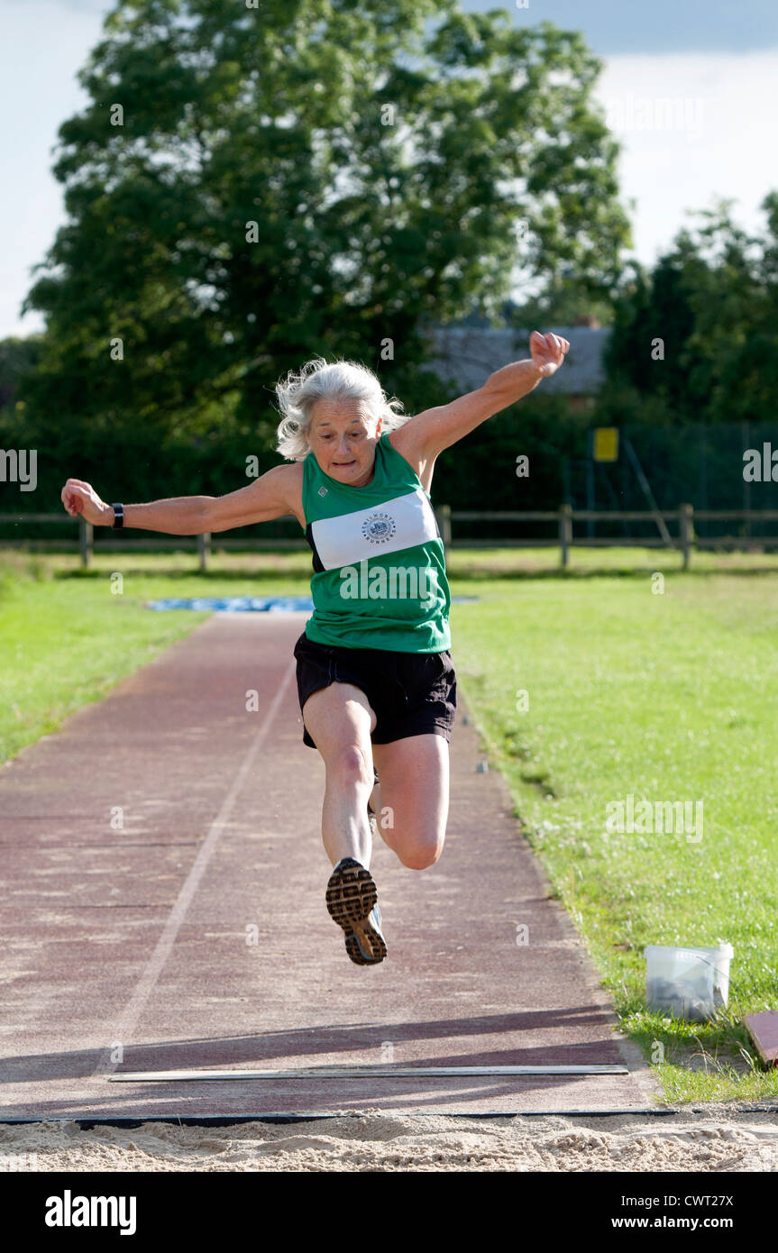 Donna anziana nel salto in lungo la concorrenza Foto Stock