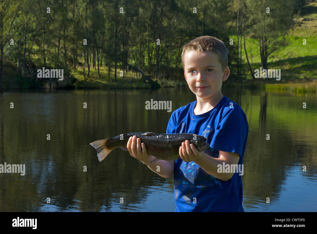 Ragazzo giovane azienda una trota ha catturato a Ghyll serbatoio di testa, South Lakeland, Parco Nazionale del Distretto dei Laghi, Cumbria, England Regno Unito Foto Stock