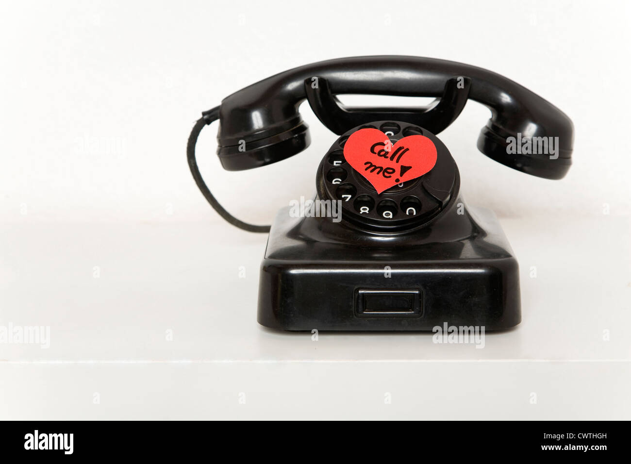 A forma di cuore di slittamento di carta sul vecchio telefono Foto Stock