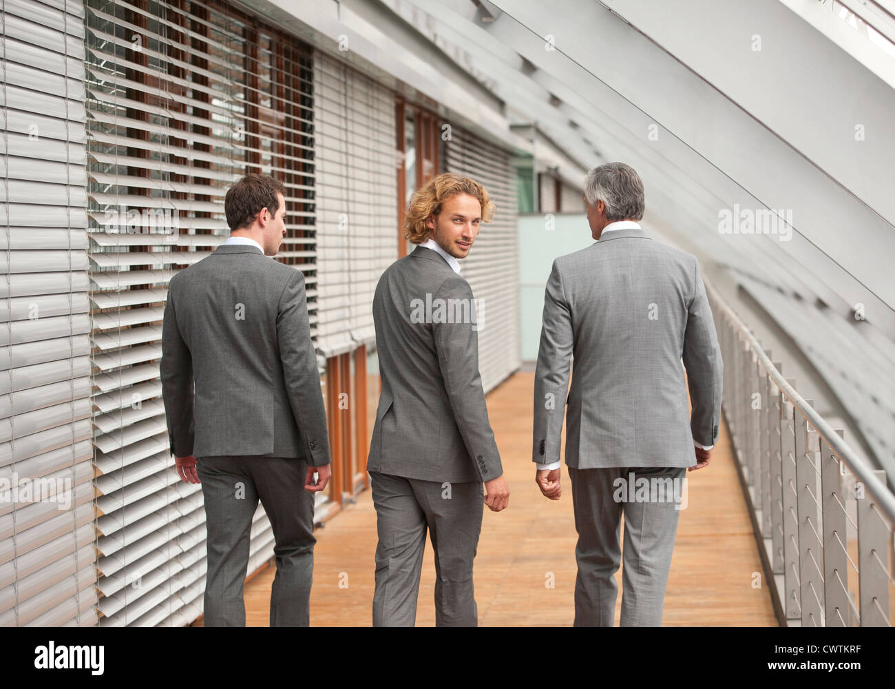 Tre uomini di affari camminando sul corridoio Foto Stock