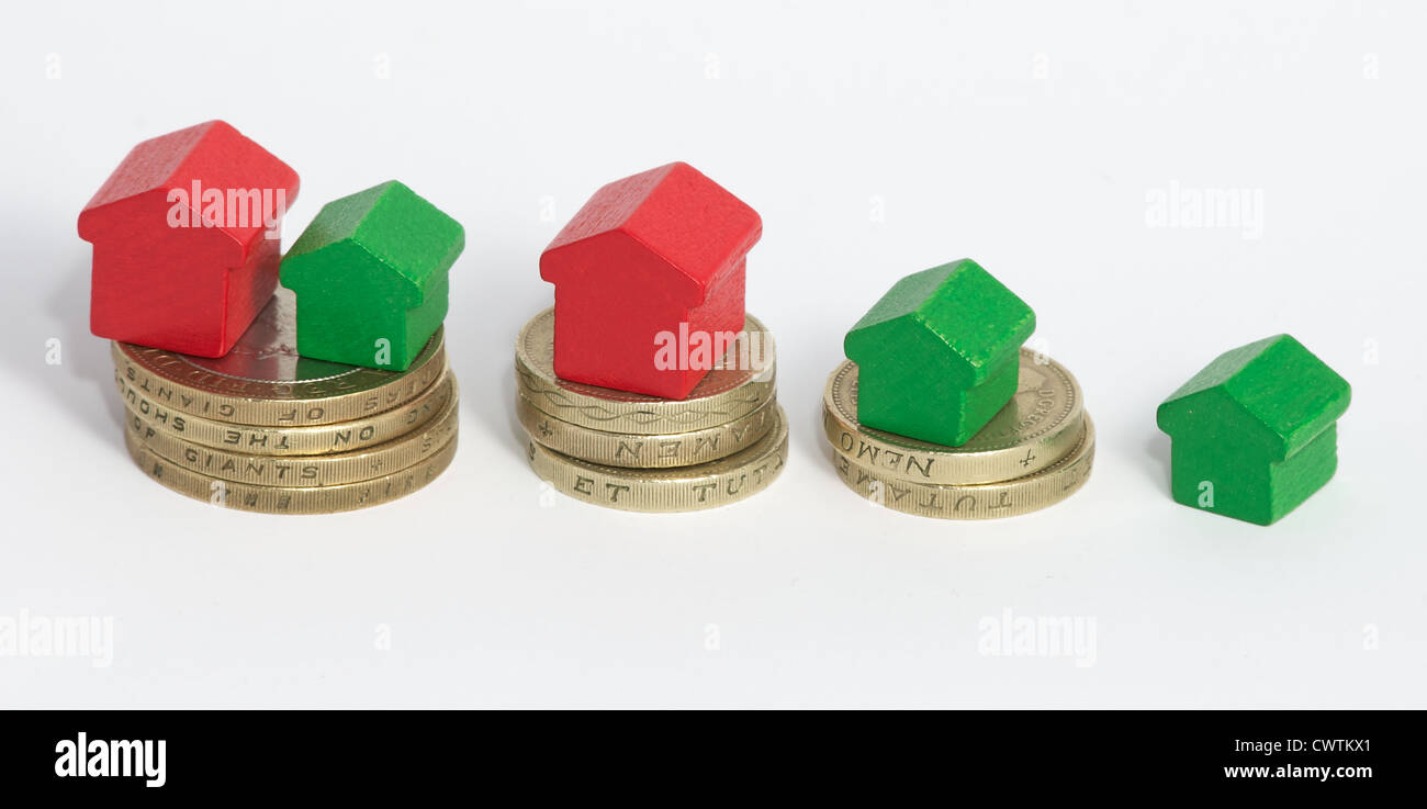 Case di monopolio si fermò sulle pile di British uno e due monete cancelletto. Significa che più soldi significa più e più grandi case Foto Stock