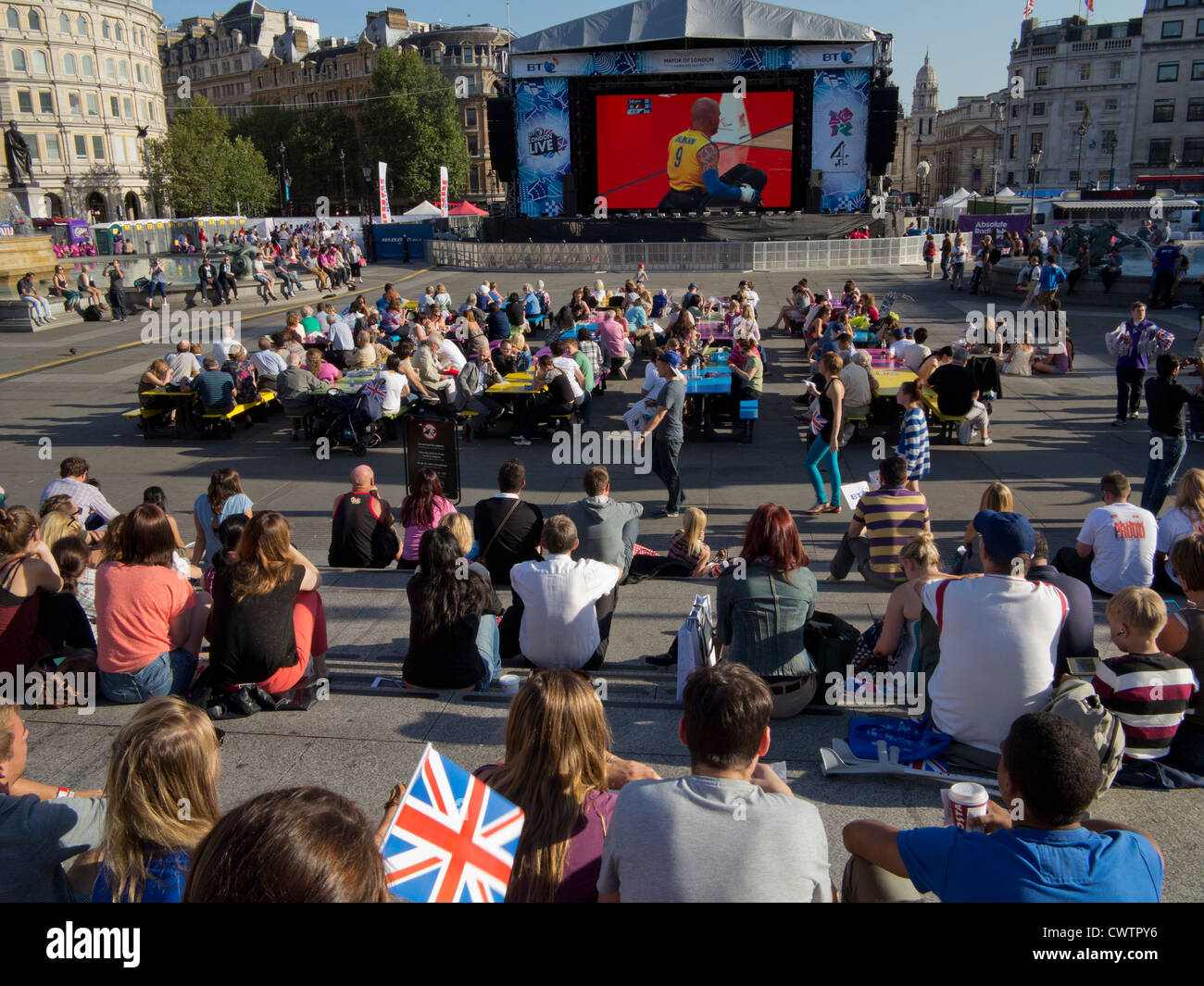 La gente guarda Londra 2012 Giochi Paralimpici su un grande schermo a Trafalgar Square, London, Regno Unito Foto Stock