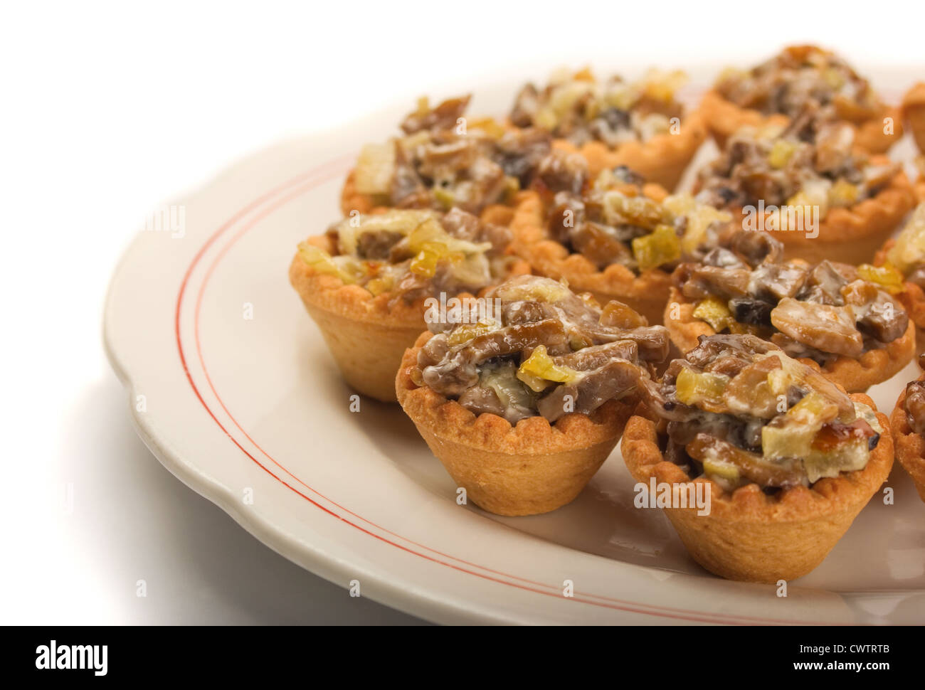 Mini Tortine con funghi, formaggi e verdure sulla piastra bianca Foto Stock