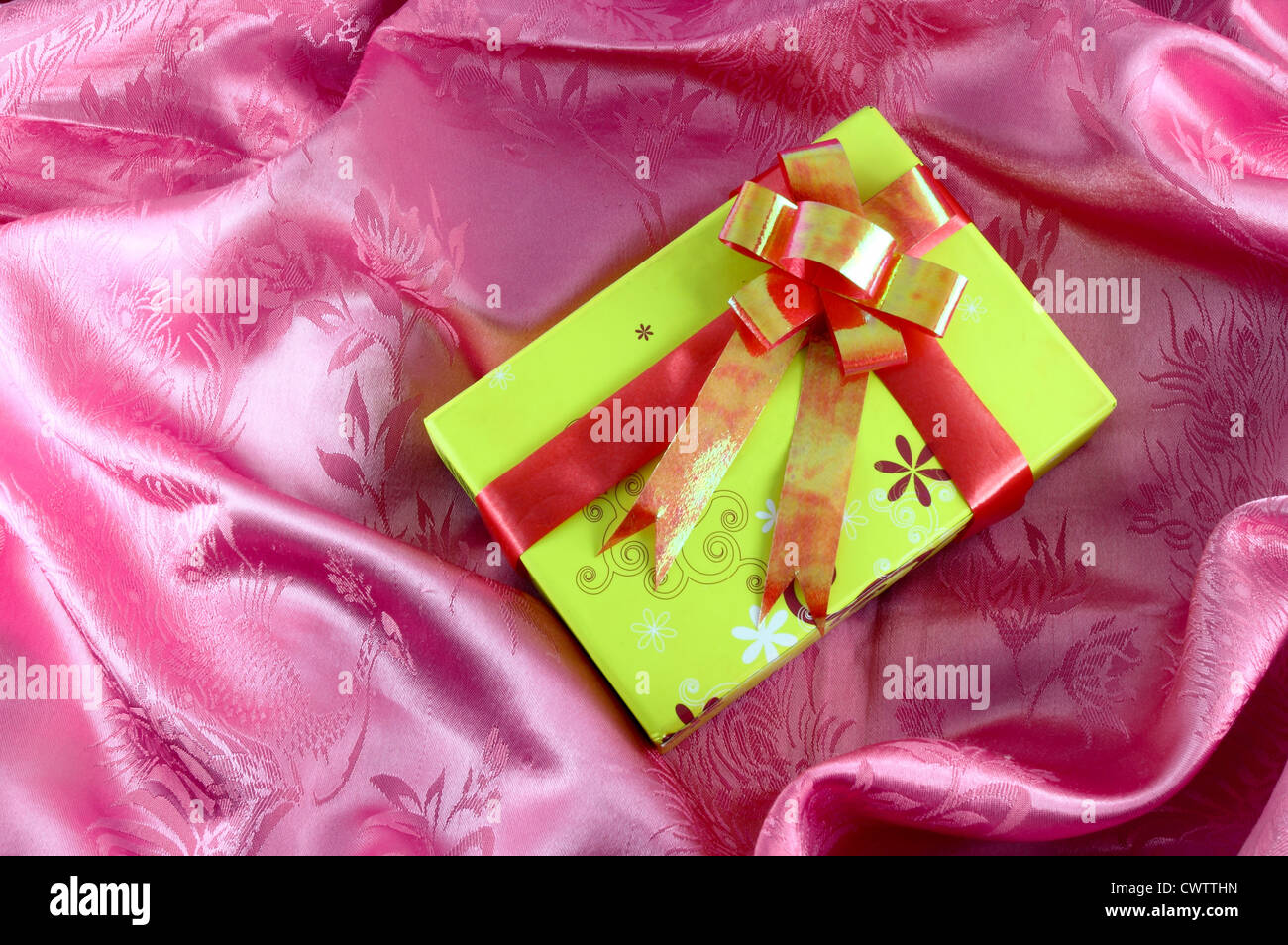 Giallo confezione regalo con nastro in raso rosa Foto Stock