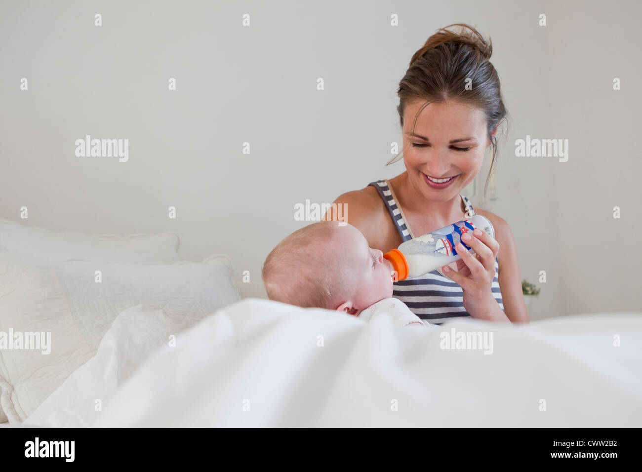 Madre sorridente biberon baby Foto Stock