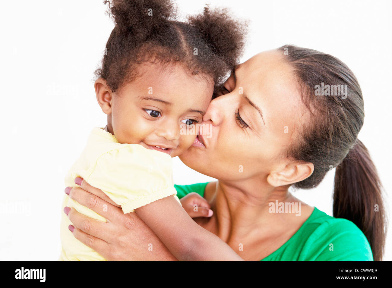 Madre e figlia baciare in cucina Foto Stock