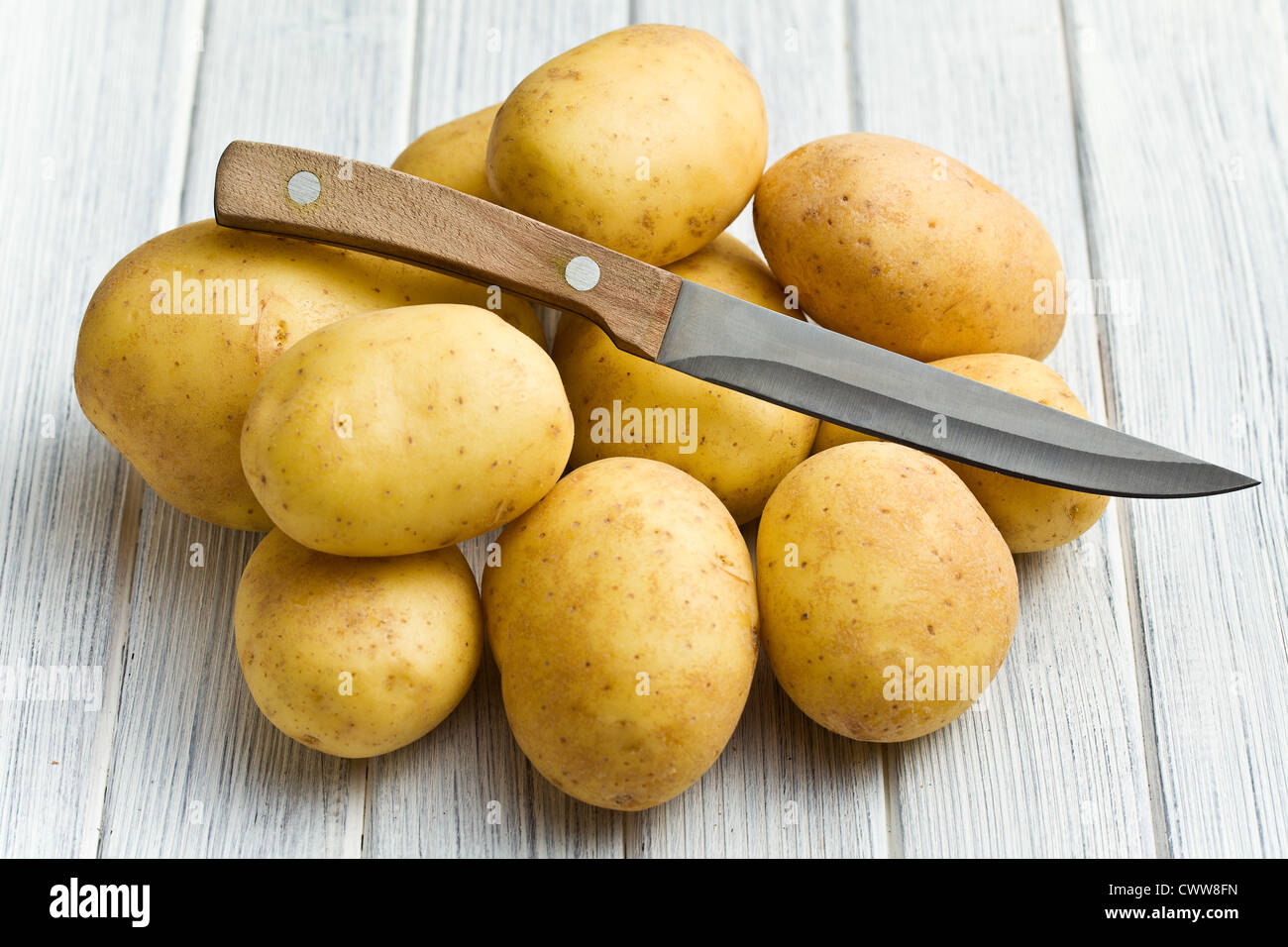 Materie di patate con il coltello sul tavolo da cucina Foto Stock