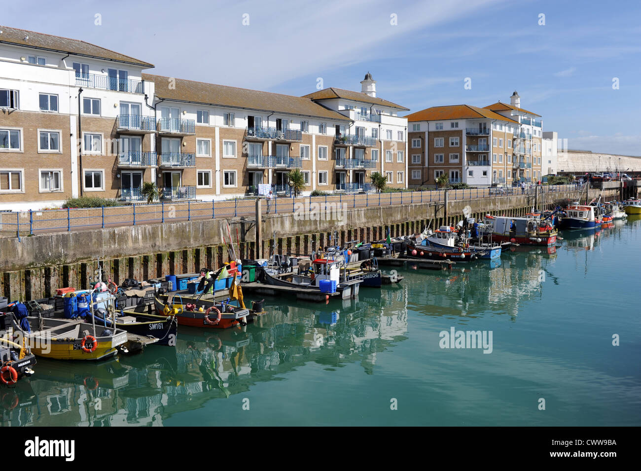 Yacht e Barche da pesca ormeggiate a Brighton Marina East Sussex Regno Unito accanto a scopo costruito appartamenti Appartamenti e Alloggiamento Foto Stock