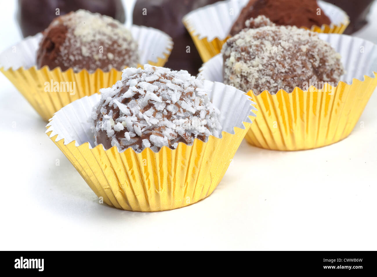 In casa tartufi di cioccolato con una varietà di condimenti come il cacao, noci di cocco, mandorle tritate. Ogni seduta in una lamina di Gold Cup. Foto Stock