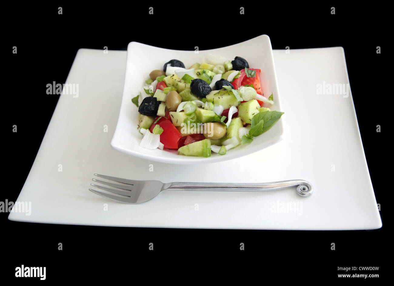 Insalata greca sulla piastra bianca shot su sfondo nero Foto Stock