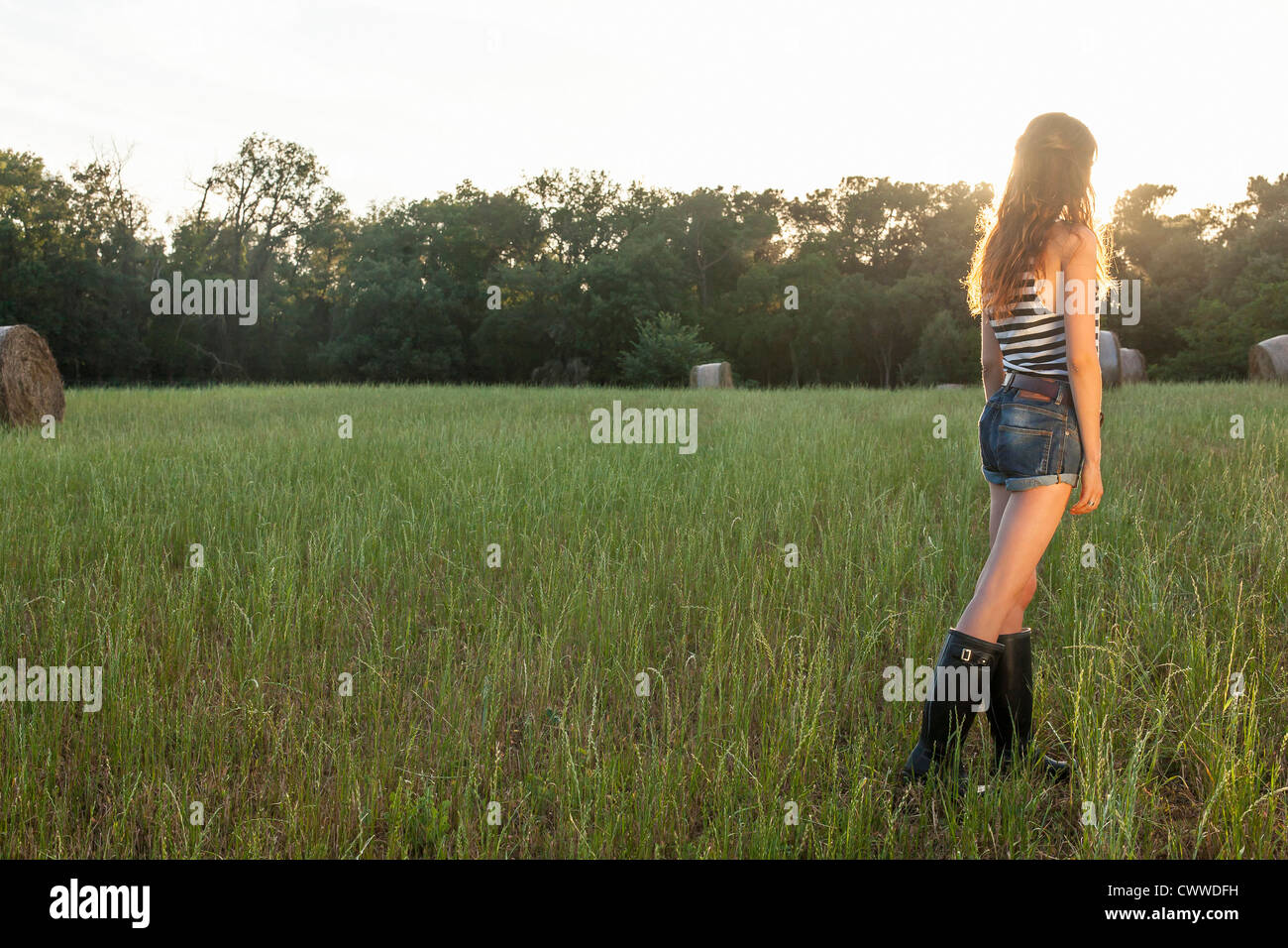 Donna in piedi nel campo erboso Foto Stock
