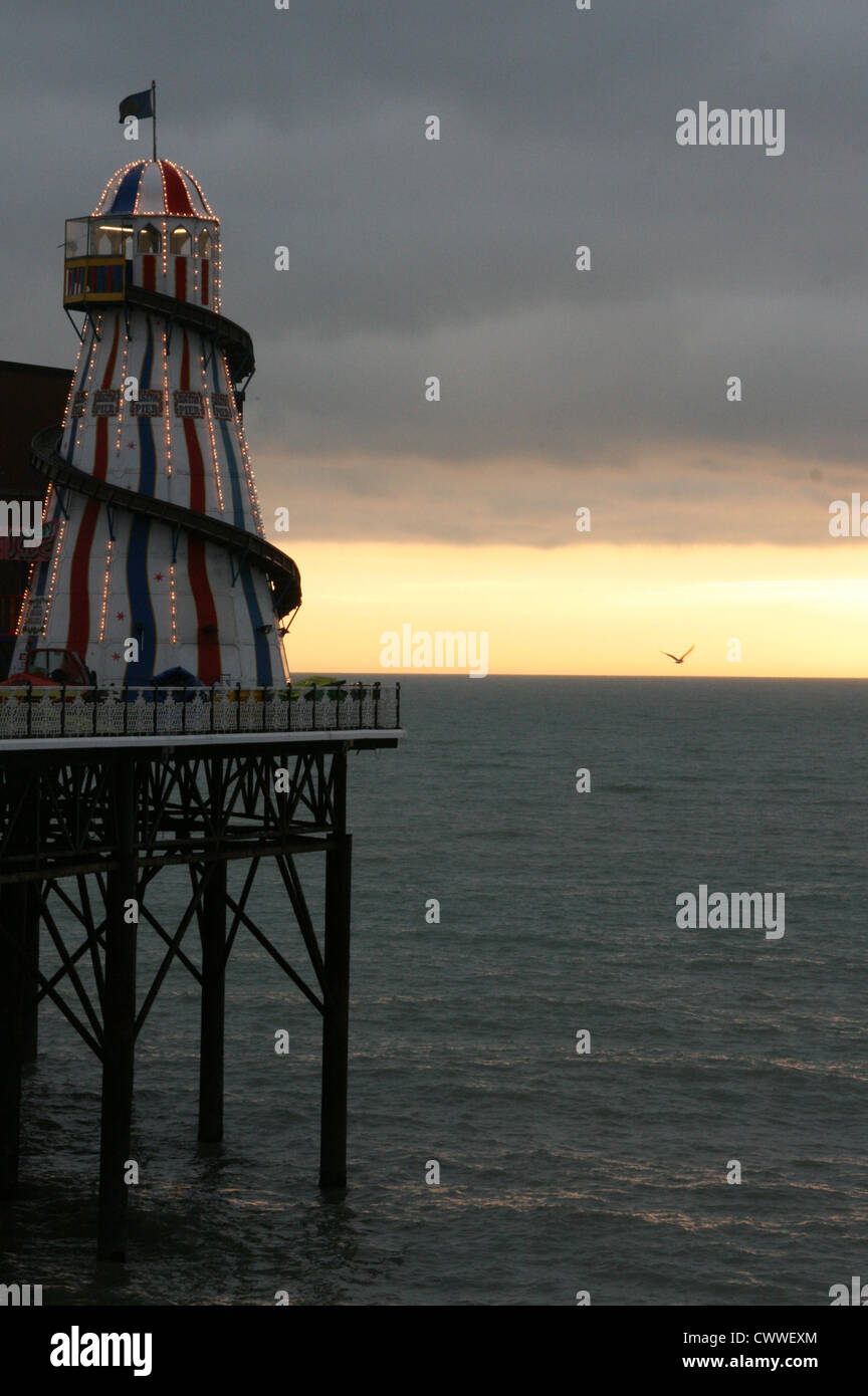 Tramonto in inverno e la Helter Skelter sul molo di Brighton, Sussex Foto Stock