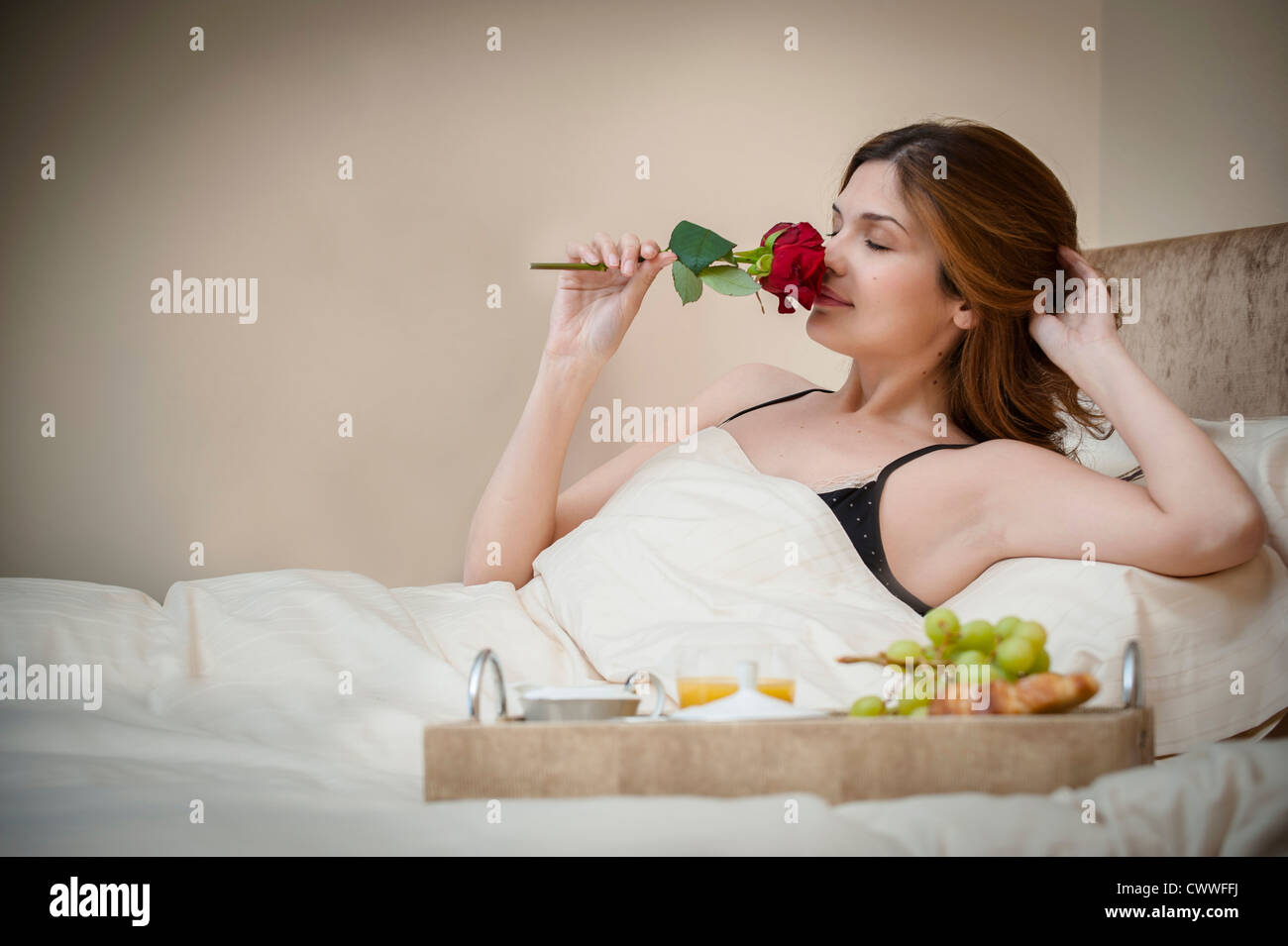 Donna con rilassante colazione a letto Foto Stock