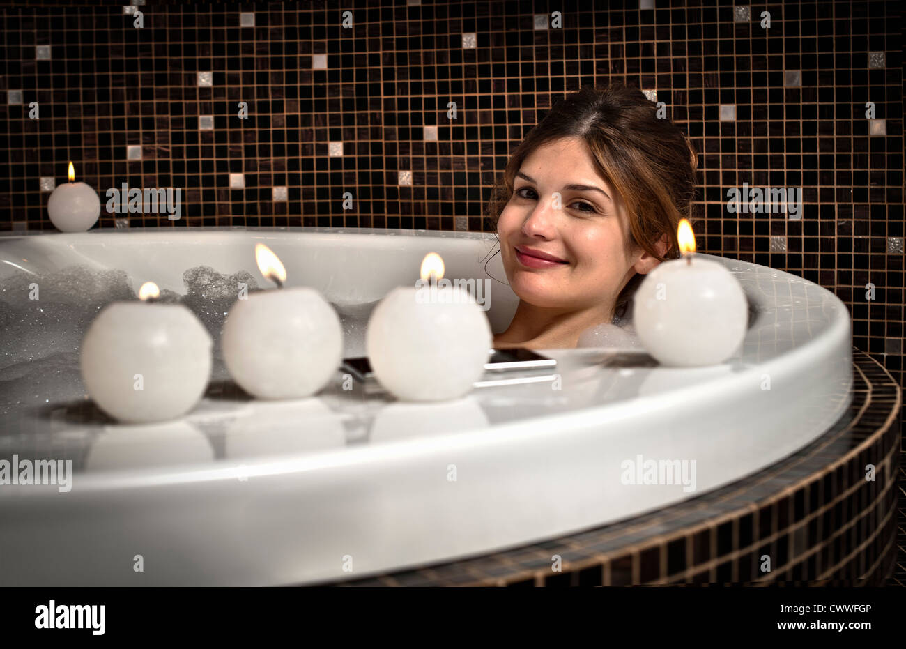 Donna sorridente relax nella vasca da bagno Foto Stock