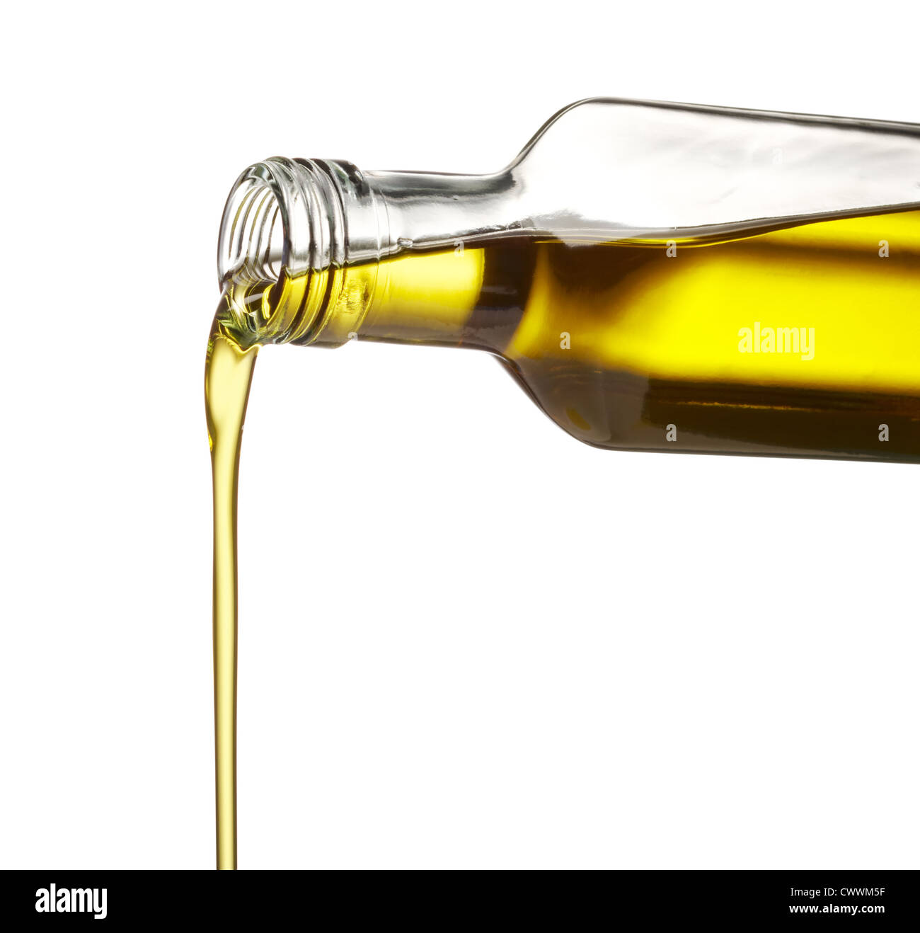 Versando l'olio d'oliva dalla bottiglia di vetro contro uno sfondo bianco Foto Stock